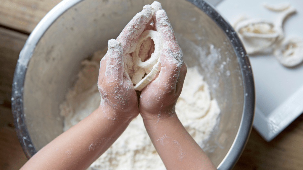 A mom laughing with her kids while they bake cookies, celebrating the joy of balancing work and family.
